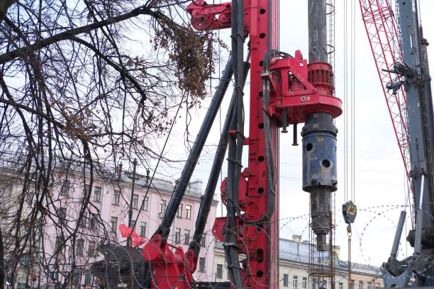 istock Hydraulic drilling machine at construction site. Drilling rig with close-up drilling pipe and tool. The device of piles on the background of the blue sky. Heavy duty machinery at building 2199179256