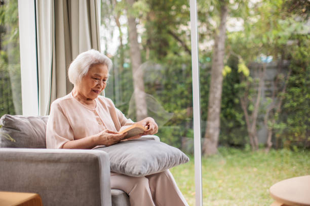 istock Older Thai Woman Reading a Book 2199180720