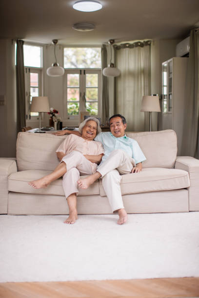istock Elderly Thai Couple Enjoying Each Other’s Company on Sofa 2199181100