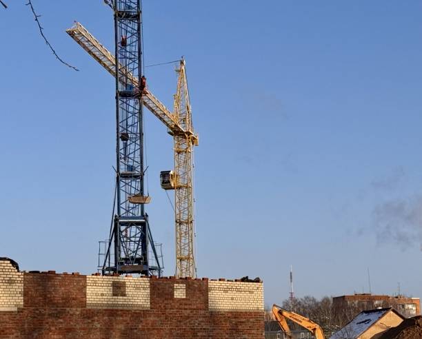 istock Construction cranes and builders work on the construction site outdoors 2199183143