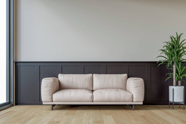 istock Modern interior: a living room with a light beige leather sofa, half deep brown wainscoting and half white plaster wall background and decoration 2199183216