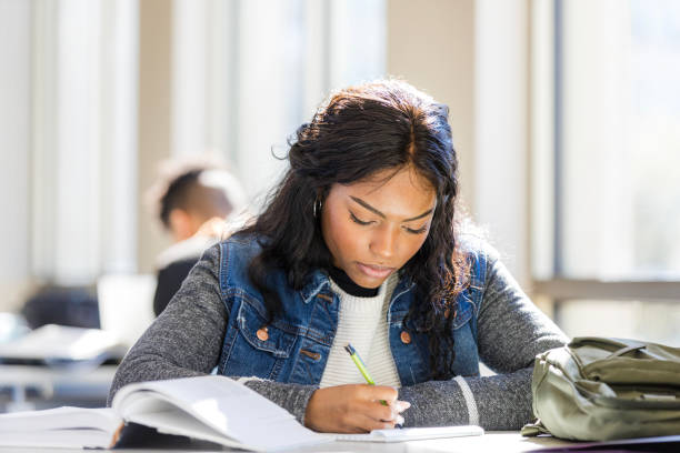 istock Focused Young Woman Studying in a Bright Classroom 2199184298