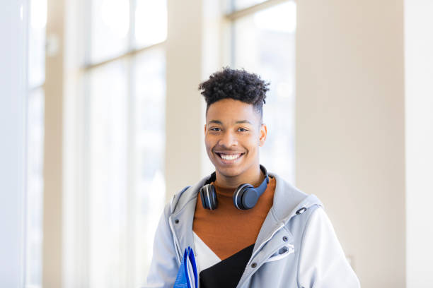 istock Happy young student smiling in college hallway 2199184312