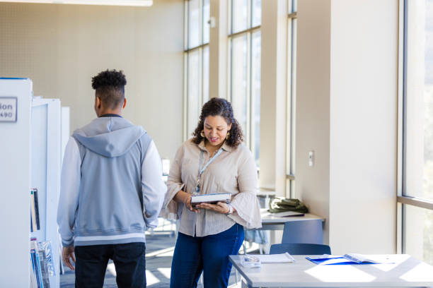 istock Teacher and Student Having a Discussion in a Bright Classroom 2199184317