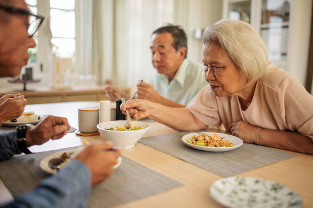 istock Two Senior Thai Couples Enjoying a Meal Together 2199185011