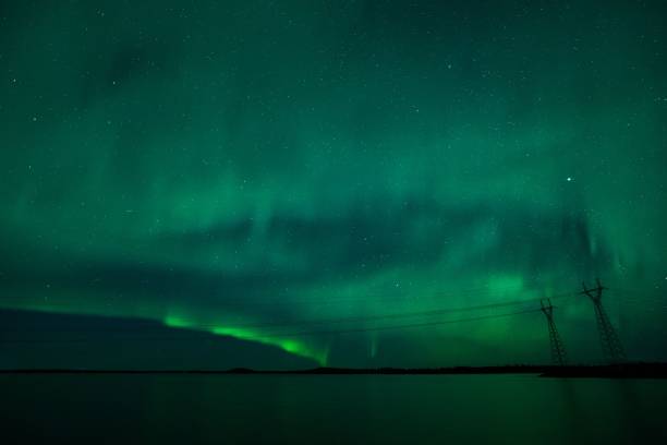 istock Northern Lights over a serene lake with power lines 2199185213