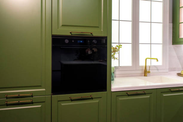 istock Built in black electric oven built into green kitchen cabinet 2199186901