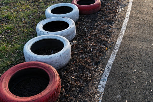 istock Recycled tires painted red and white are lined along a park pathway, demonstrating community efforts in repurposing materials for beautification 2199191652
