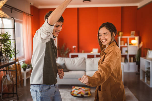 istock cheerful young couple have fun at home while dance energetically 2199199401