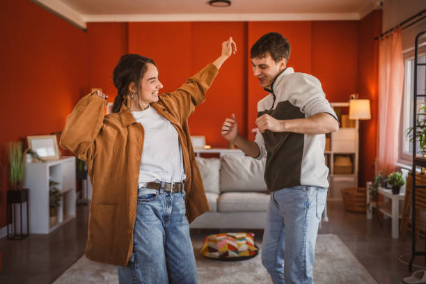 istock cheerful young couple have fun at home while dance energetically 2199203579