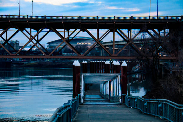 Color Photograph of the Eastbank Esplanade in Portland, Oregon during blue hour with the Burnside Bridge in the background.