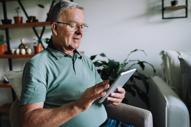 istock Senior man using a digital tablet in the living room 2199234198