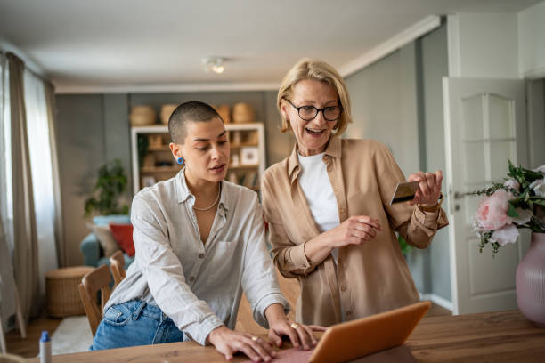 istock Two mixed-age women browsing an online store with a tablet and credit card 2199237686