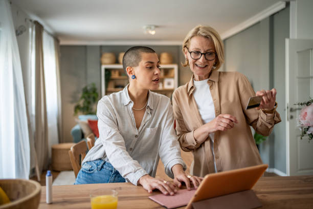 istock Two mixed-age women browsing an online store with a tablet and credit card 2199237709
