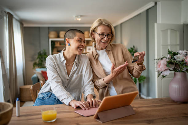 istock Two mixed-age women browsing an online store with a tablet and credit card 2199237716