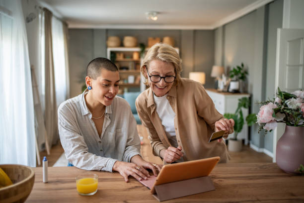 istock Two mixed-age women browsing an online store with a tablet and credit card 2199237928