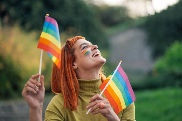 istock Happy activist holding rainbow flags celebrating lgbtq plus pride in public park 2199248587