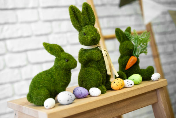 istock Easter bunnies and colorful eggs on a wooden table 2199249051