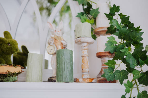 istock Decorative shelf with candles, greenery, and a bunny figurine in a bright space 2199249365