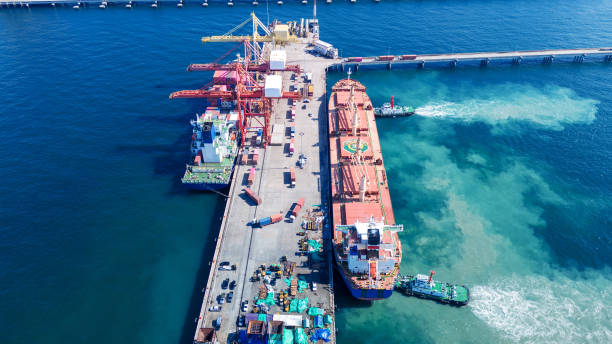 istock Tug boat pulling Cargo container ship go to international yard port. technology freight shipping with smart port. Cargo ship at logistic warehouse. 2199263957