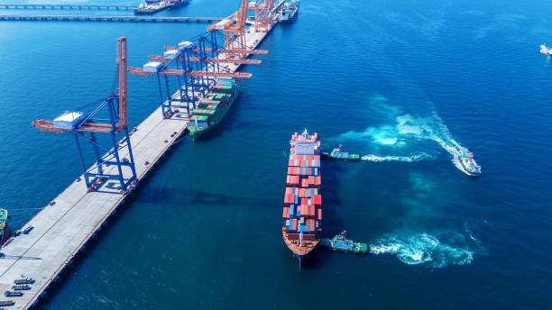 istock Tug boat pulling Cargo container ship go to international yard port. technology freight shipping with smart port. Cargo ship at logistic warehouse. 2199264008