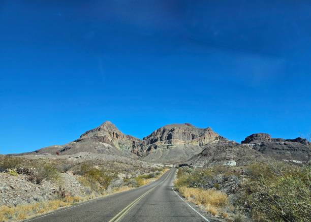 istock Road into a vast desert landscape 2199264085