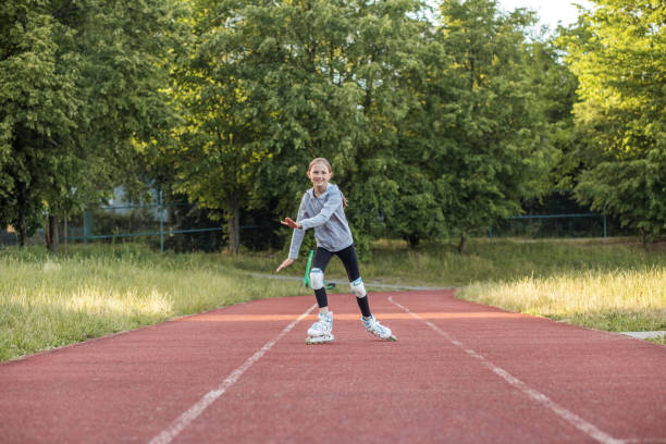 istock Tween roller skating on a red track surrounded by greenery during a sunny day 2199272563