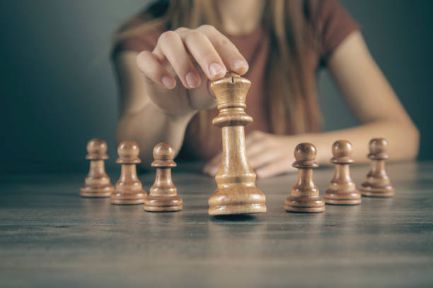 istock woman alone plays with chess pieces 2199273403