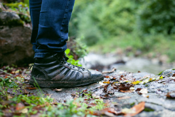 a man in dirty shoes in the fall stands