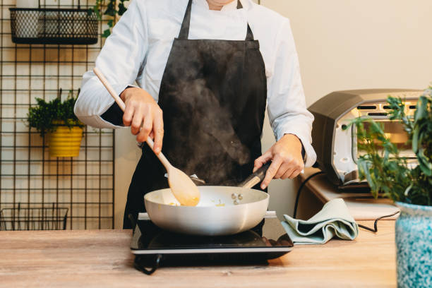 Chef cooking and stirring food in a pan