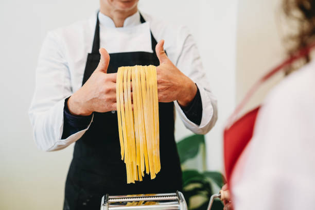 istock Chef proudly showing fresh pasta from pasta machine 2199275205