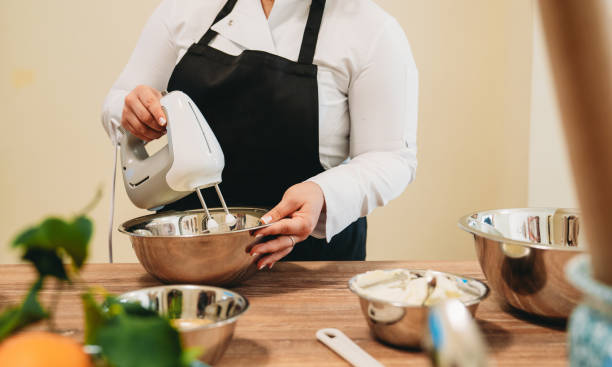 istock Pastry chef using electric hand mixer preparing dough in metal bowl 2199275216