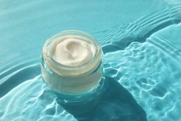 istock Jar with moisturizing cream in water on light blue background 2199276376