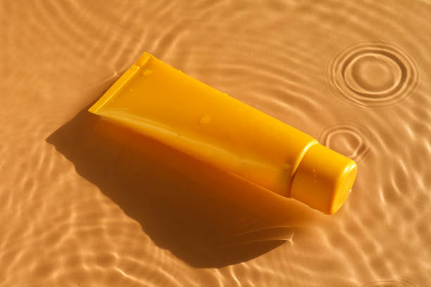 istock Tube with moisturizing cream in water on orange background 2199276396