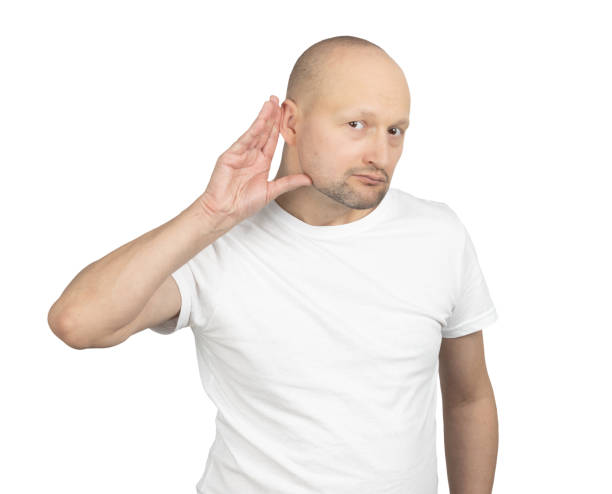 istock Curious bald man listening attentively with a hand to his ear 2199278243