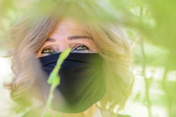 close up of two young Iranian women in veil looking at the camera against green background