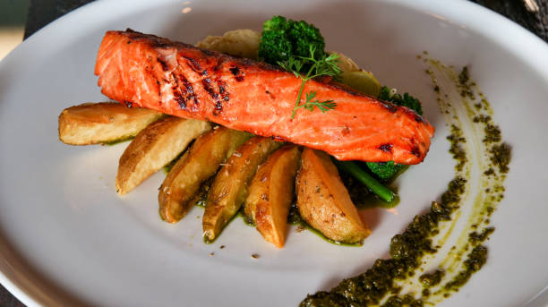 istock Grilled Salmon with Roasted Potatoes and Vegetables on White Plate 2199278804