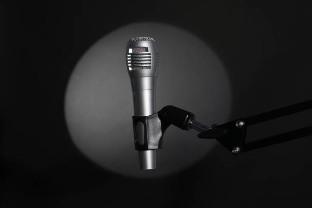 istock Stand with microphone in spotlight on black background. Sound recording and reinforcement 2199279297