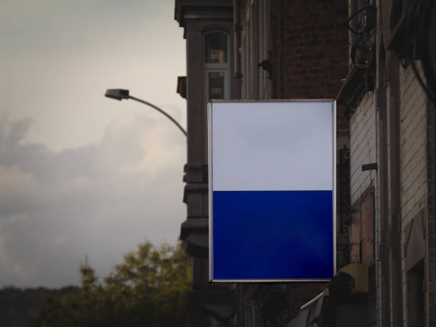 istock A blank white and blue sign hangs above a storefront, awaiting custom branding. Subtle street details frame the modern façade in Germany. 2199279680