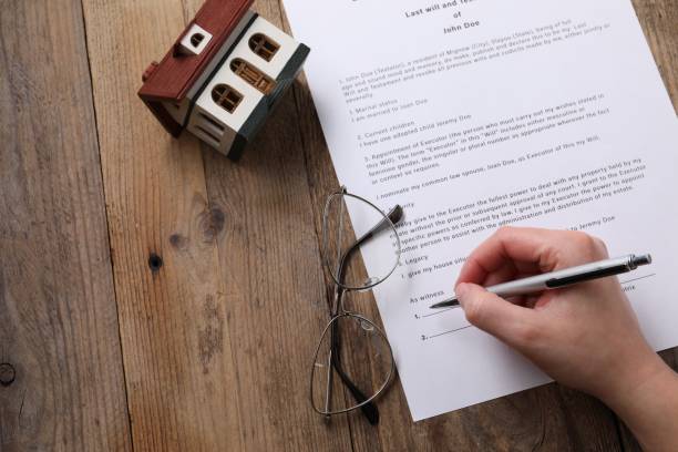 istock Woman signing Last Will and Testament at wooden table, top view. Space for text 2199281069