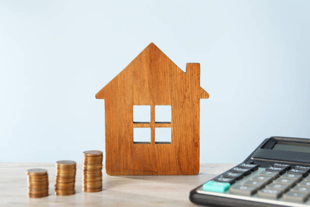 istock House model, calculator and coins on wooden table against light blue background 2199281104