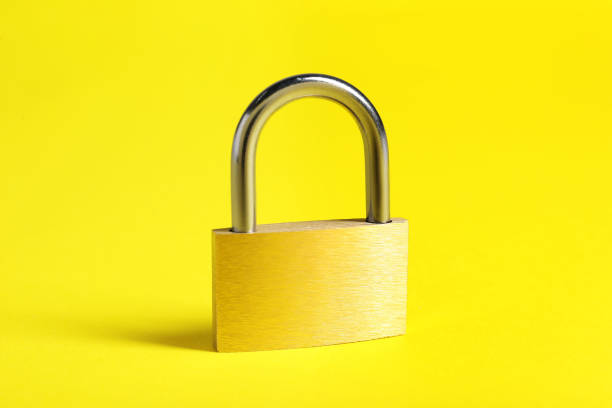 istock One locked steel padlock on yellow background 2199281110