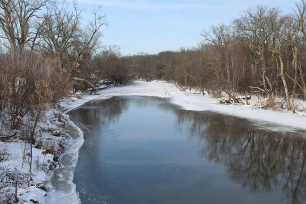 istock Partially frozen Des Plaines River with a reflection and snow at Camp Ground Road Woods in Des Plaines, Illinois 2199282037