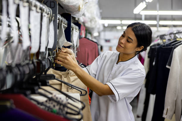 istock Employee working at an industrial laundry hanging clothes 2199284800