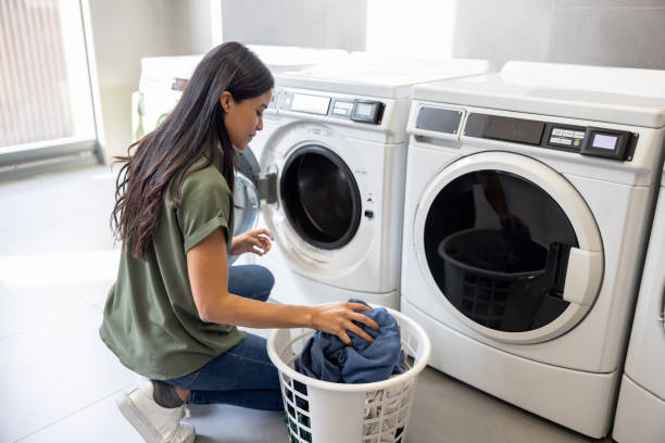 istock Woman washing her clothes at the laundry 2199284836