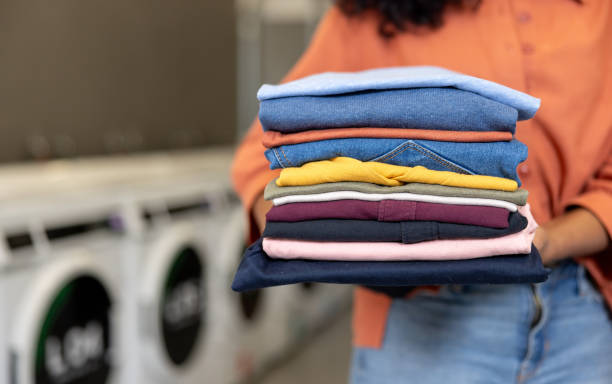 istock Close-up on a woman at a laundromat carrying folded clothes 2199284872