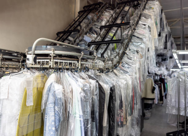 istock Clothes hanging on the conveyor belt at an industrial laundry 2199286817
