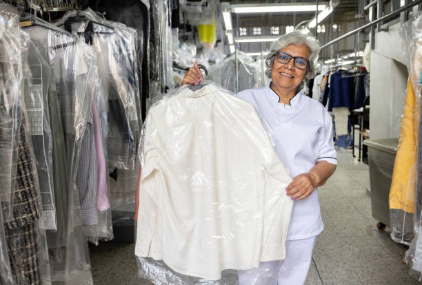 istock Happy laundry employee holding a dry cleaning bag 2199286849