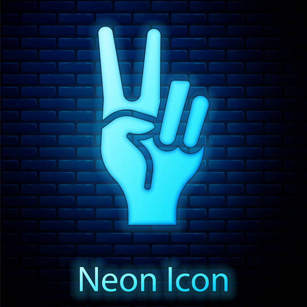 istock Glowing neon Hand showing two finger icon isolated on brick wall background. Hand gesture V sign for victory or peace. Vector 2199288176