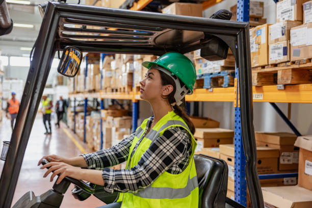 istock Efficient Warehouse Operations: Female Forklift Driver Poses and Drives Worklift at Distribution Warehouse. 2199291880